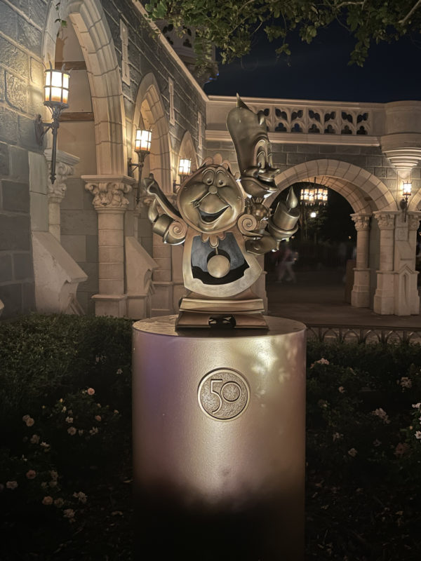 Lumiere (16) and Cogsworth (17) in their "cursed" versions appear in Fantasyland.