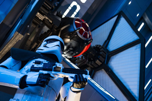 A First Order Stormtrooper stands guard in the Star Destroyer hangar bay beneath a docked TIE fighter. Photo credits (C) Disney Enterprises, Inc. All Rights Reserved.