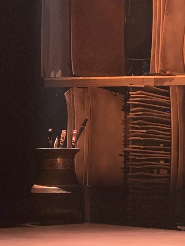 Everything on stage is larger than life, including a large cup of pencils, pens, and paintbrushes!