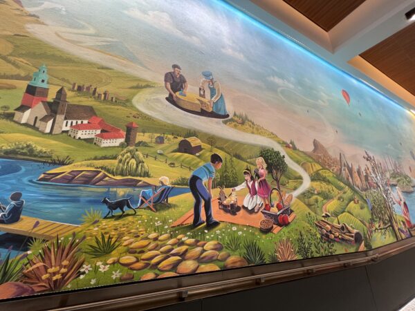 The mural shows people from around the world enjoying coffee and food.