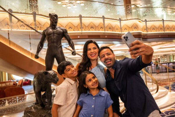 Family takes a photo in front of Black Panther statue onboard the Disney Destiny