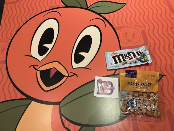 Complimentary snacks and sticker resting on a colorful Orange Bird table.