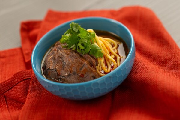 Beef Noodle Soup Bowl with slow-braised beef shank, green onion, and house-made chili oil