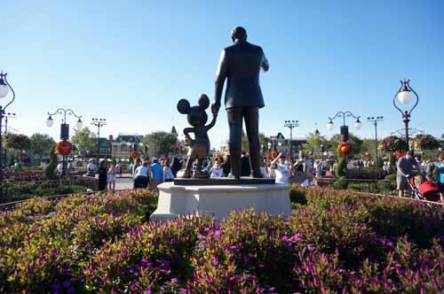 Beautiful purple flowers surround the Partners Statue with Walt and Mickey.