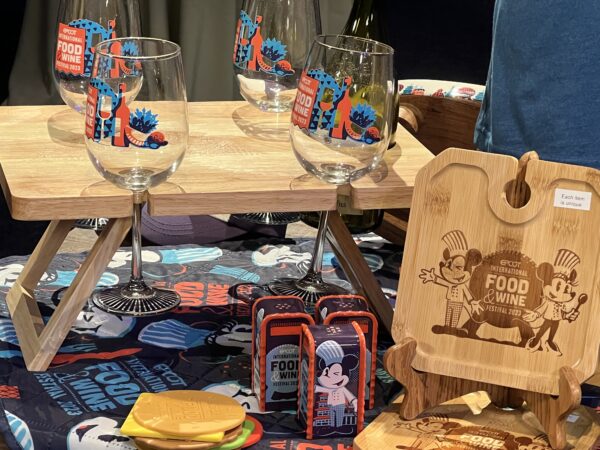 Long stem wine glasses in a wood holder, salt and pepper shakers, and coasters that look like a hamburger.