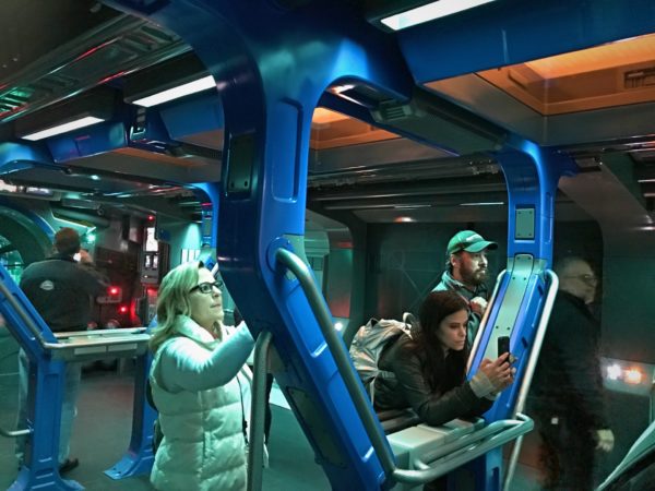 The transport ship moves, but gently. You can hang onto the bars while standing during your journey. 